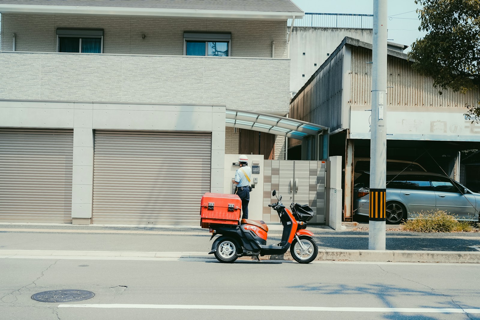 A courier scooter beside a closed shutter